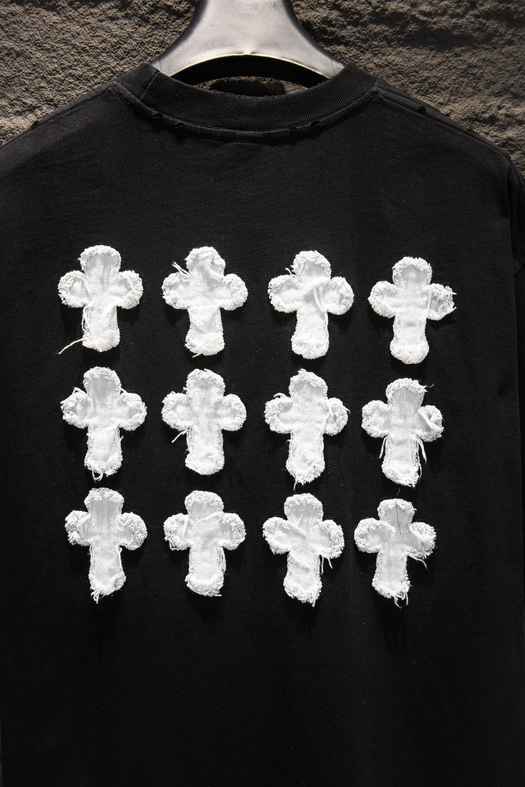 Black T-shirt front with multiple white cross appliques