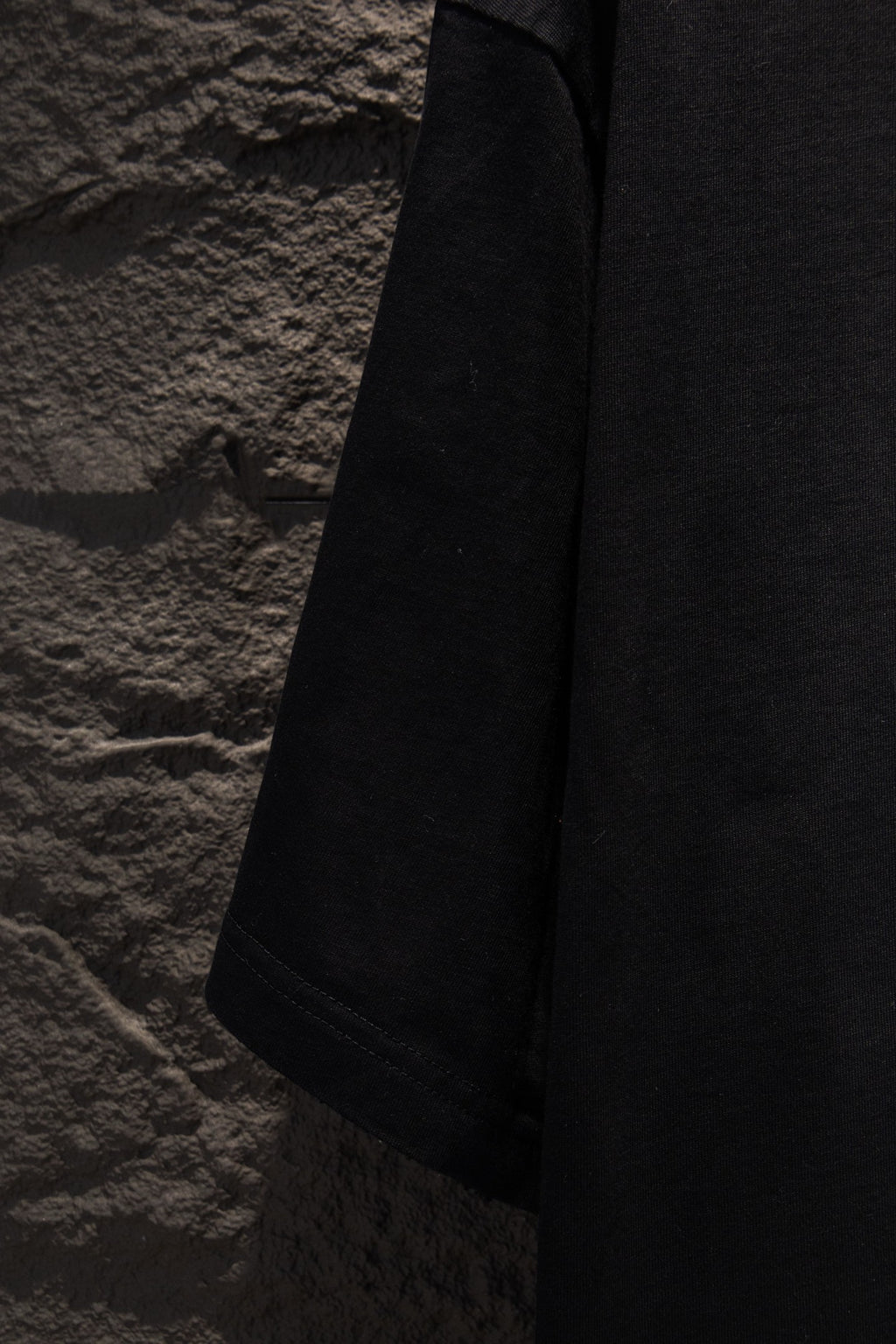 Black T-shirt sleeve and side seam view