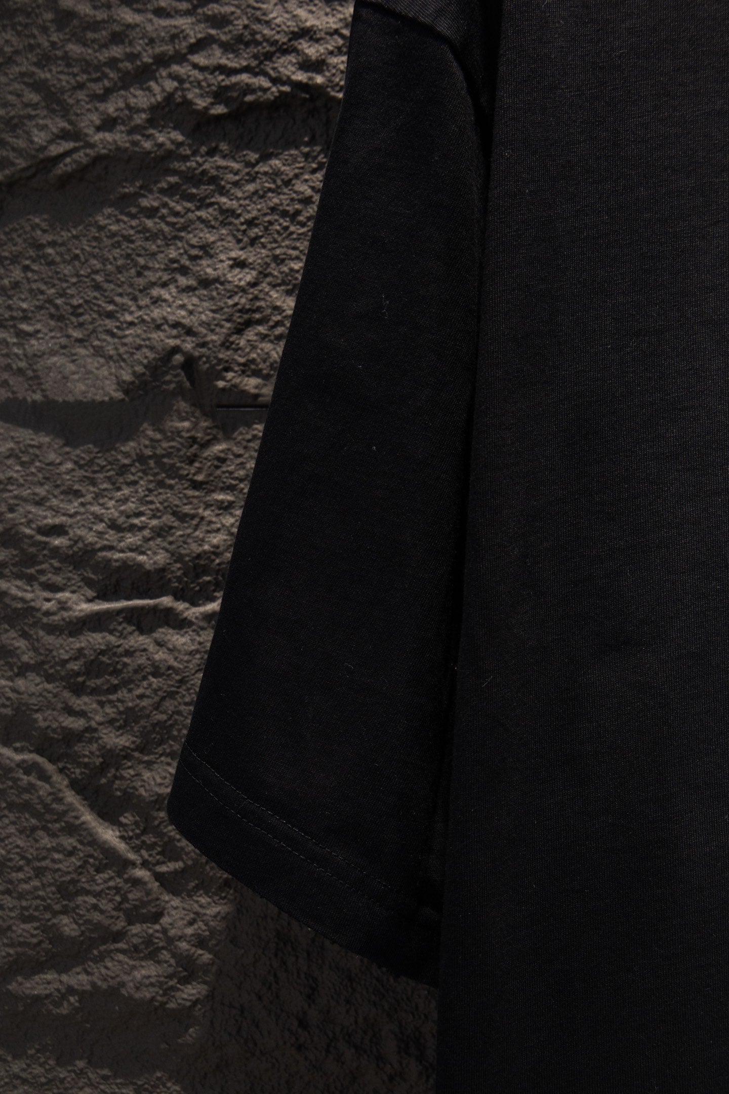 Black T-shirt sleeve and side seam view