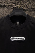 Black T-shirt neckline with embroidered chest patch