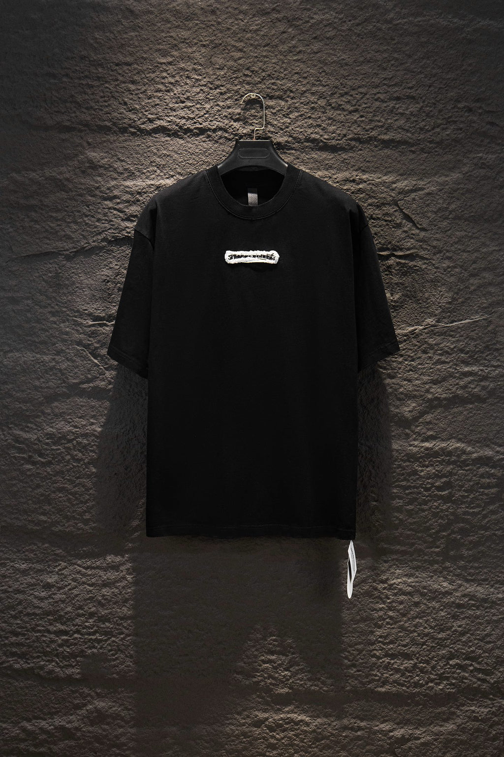 Black short-sleeve T-shirt with small chest logo patch