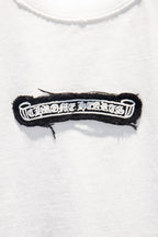 Black embroidered logo patch detail on white T-shirt chest
