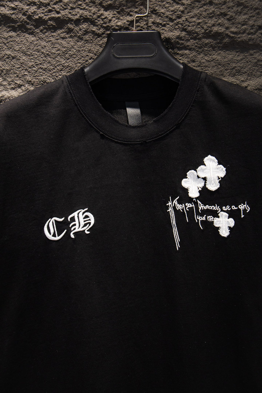 Black short-sleeve T-shirt close-up of neckline and left chest logo