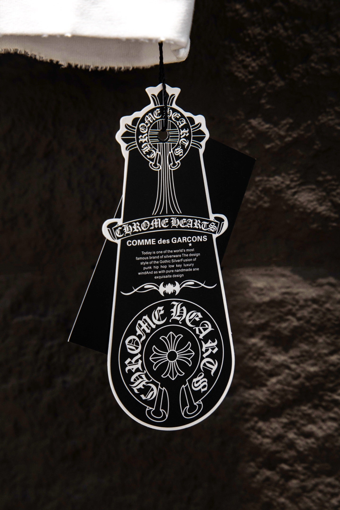 Black branded hang tag attached to T-shirt hem