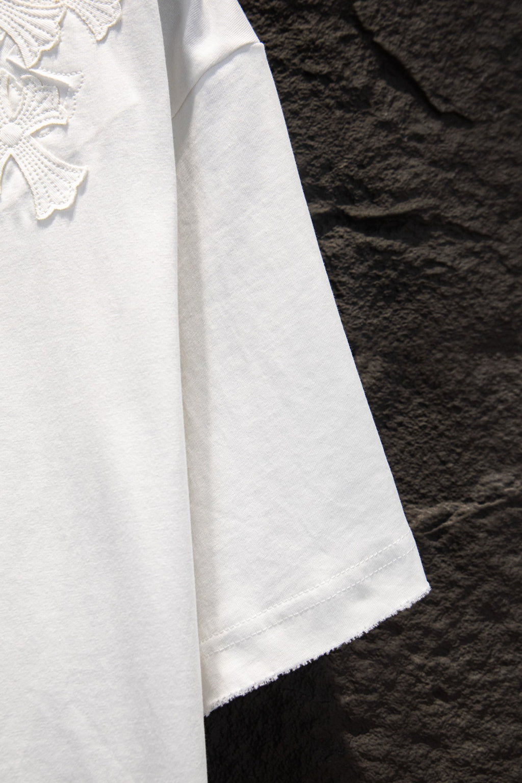 White T-shirt side view with straight hem and embroidered texture near chest