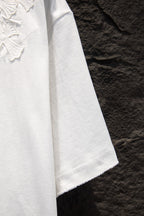 White T-shirt side view with straight hem and embroidered texture near chest