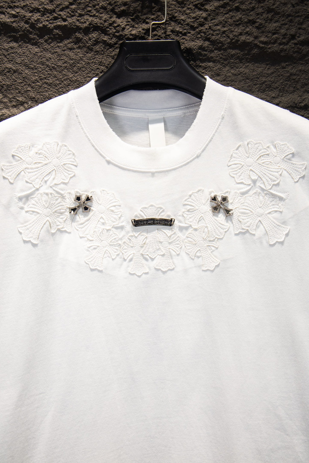 White crew-neck T-shirt with floral appliqué and beaded cross ornament