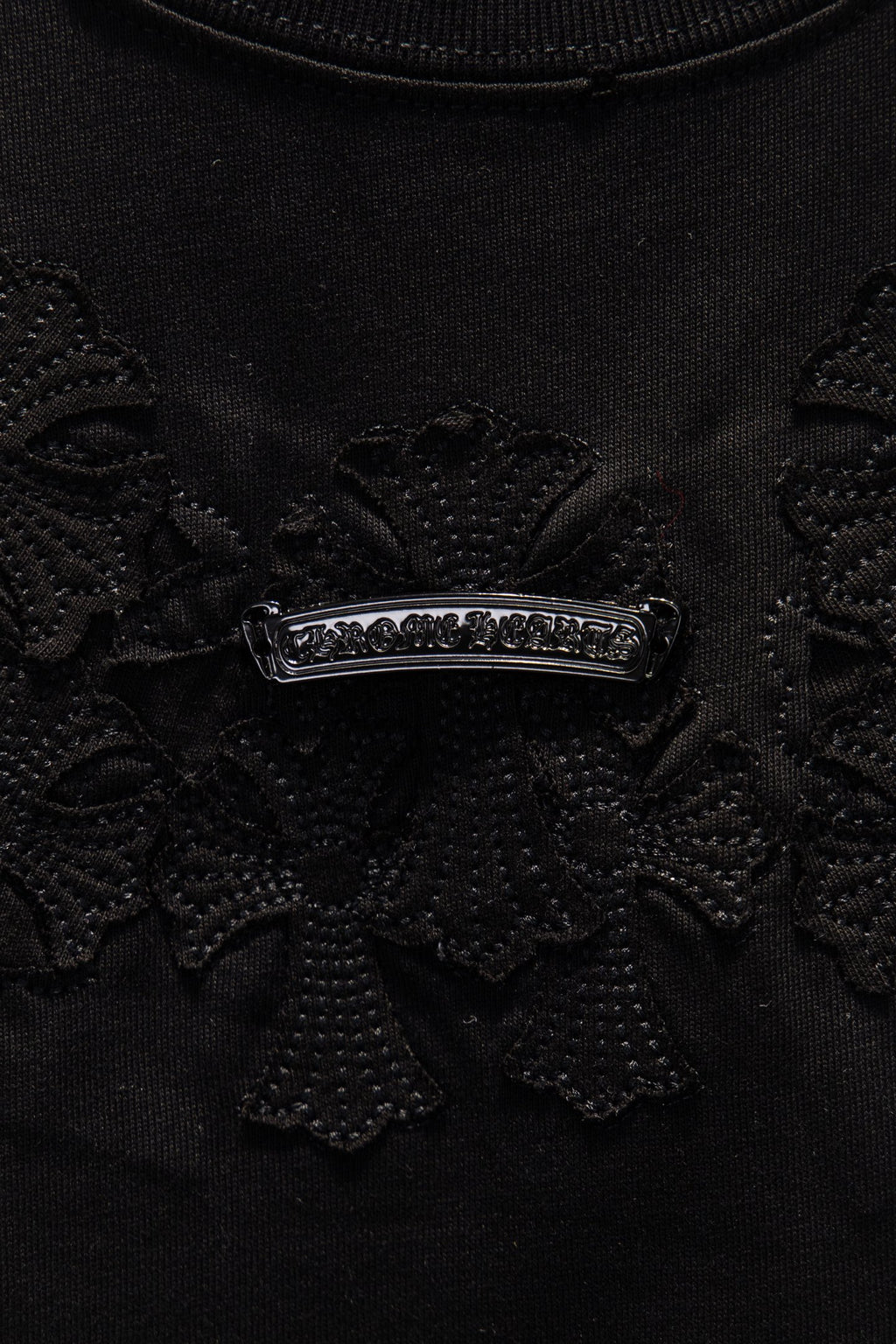 Black embroidered chest panel with a silver-tone horizontal crest detail