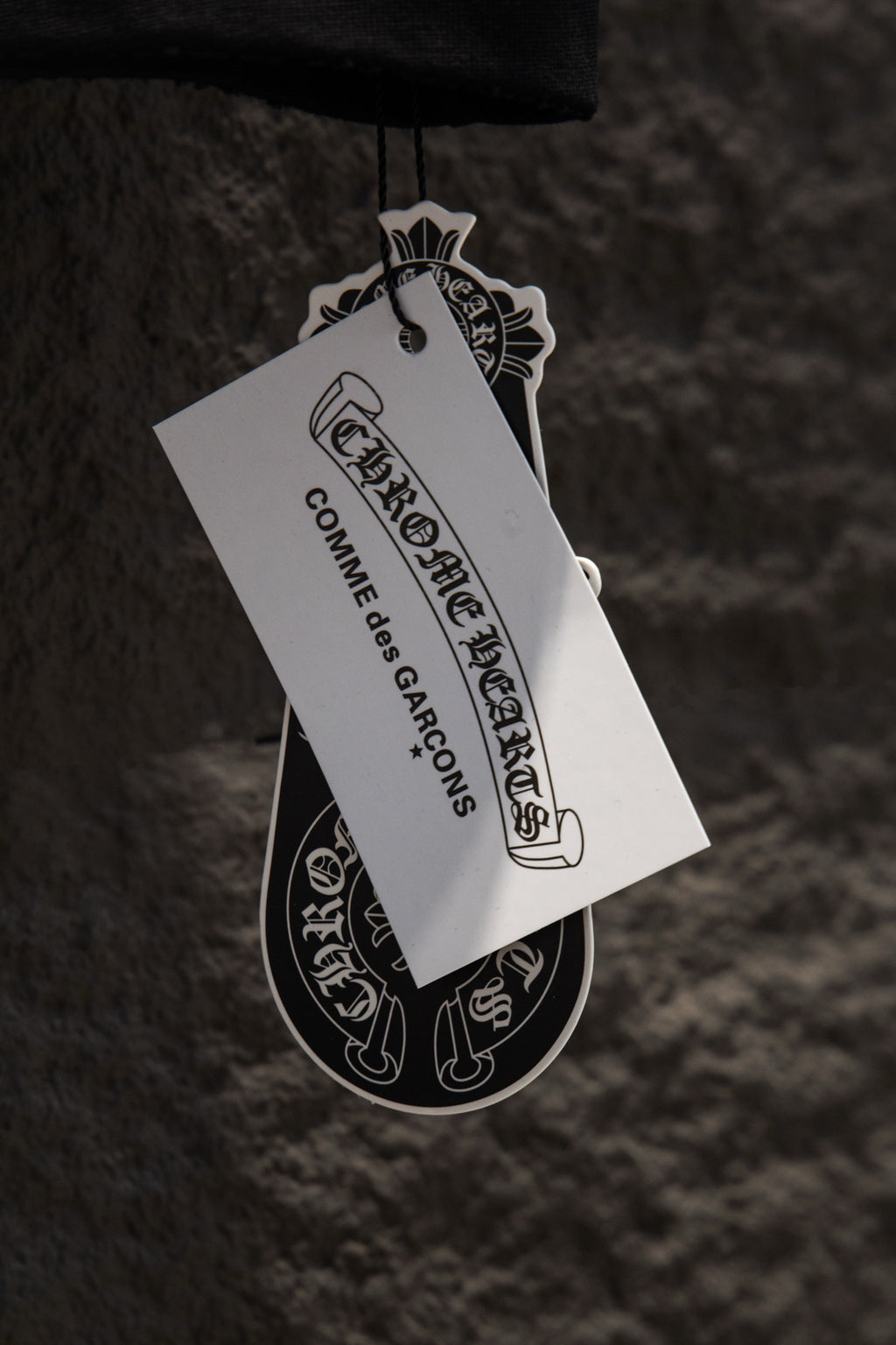 Hanging product tag attached to a black garment