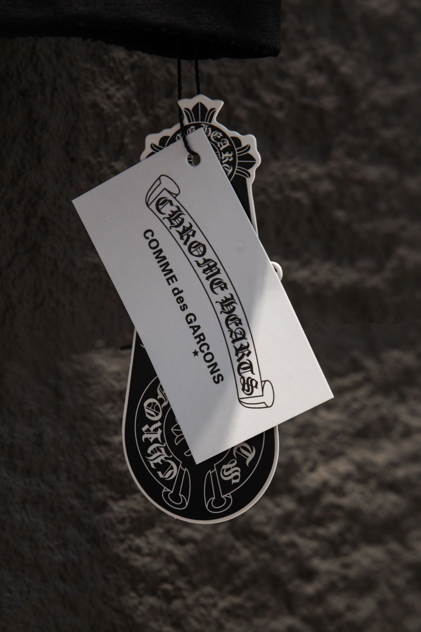 Hanging product tag attached to a black garment