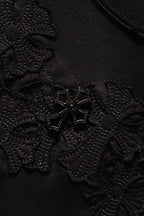 Black embroidered fabric texture with dense raised floral stitching