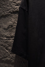 Black short-sleeve T-shirt angled side view showing shoulder and sleeve