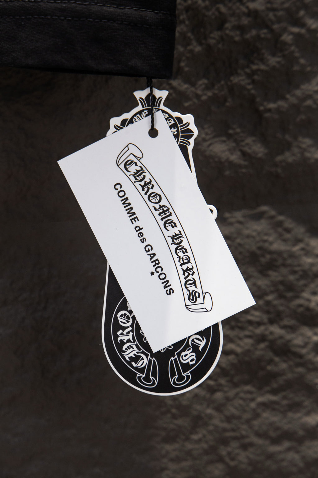 Black T-shirt with white hang tag attached near the hem