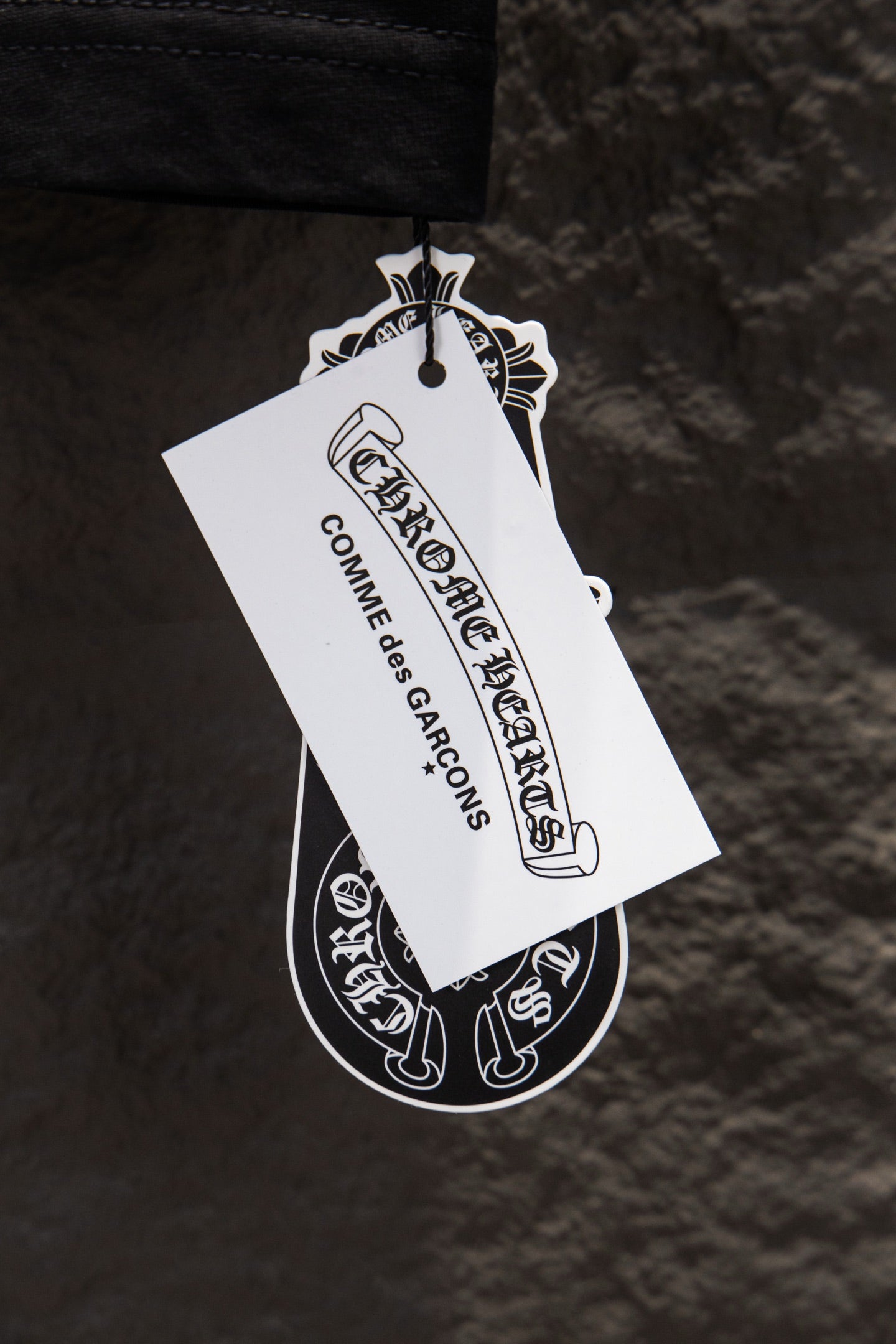 Black T-shirt with white hang tag attached near the hem