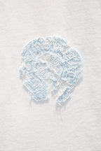 Light blue embroidered face patch on white T-shirt