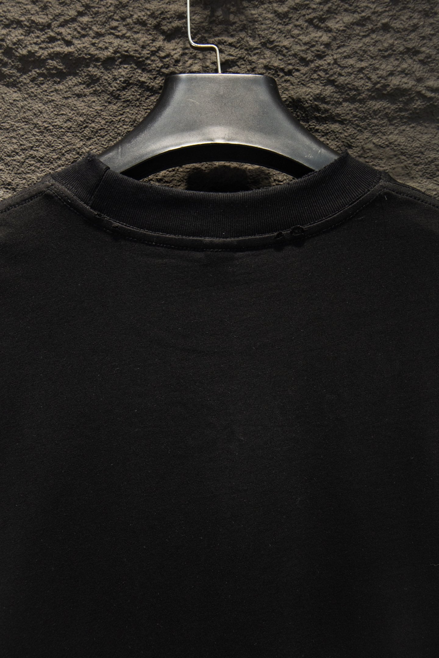 Black short-sleeve T-shirt collar view on hanger