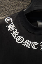 Black T-shirt sleeve with white embroidered-style logo graphic text