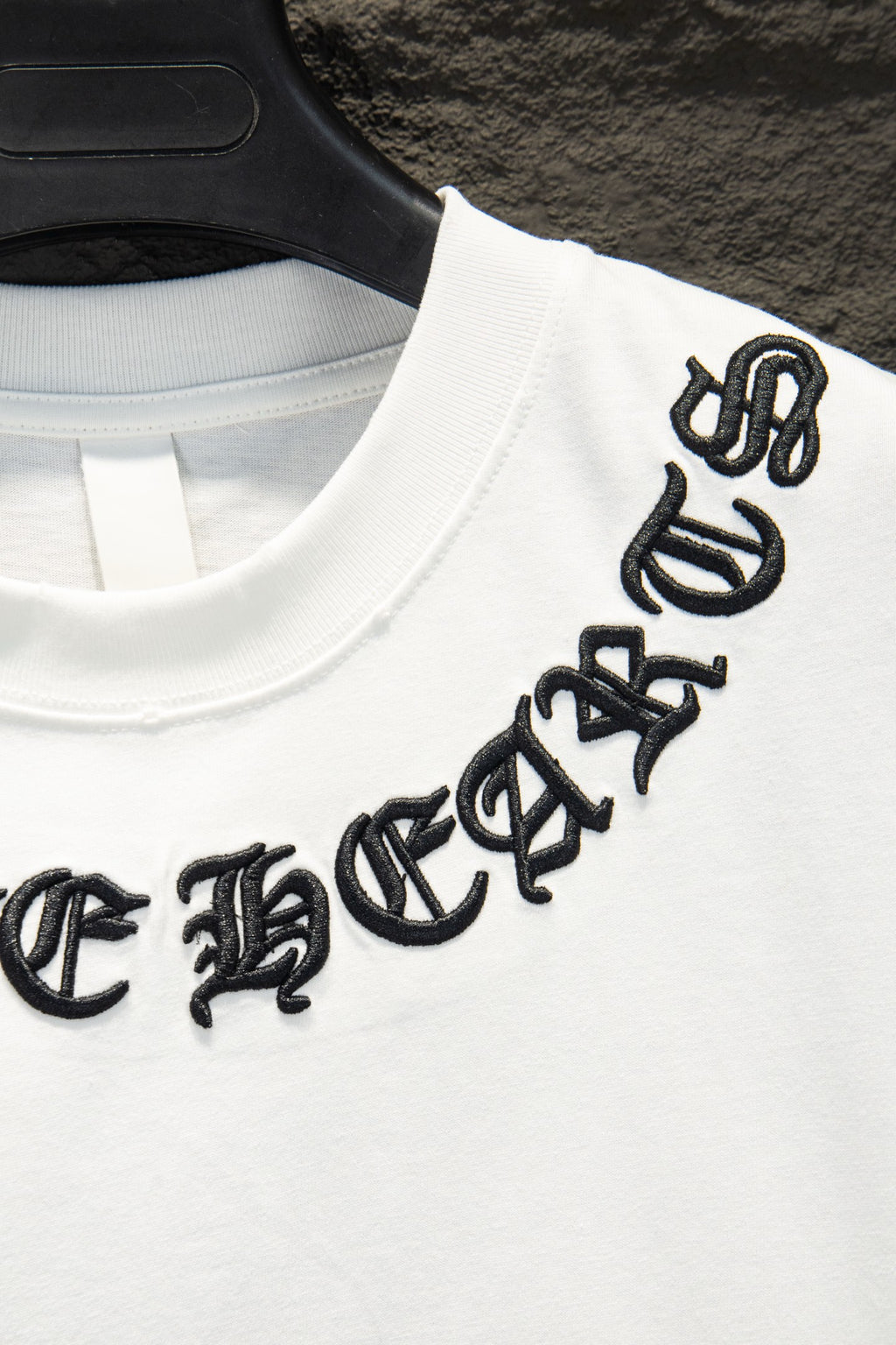 White T-shirt with black embroidered logo on sleeve/shoulder