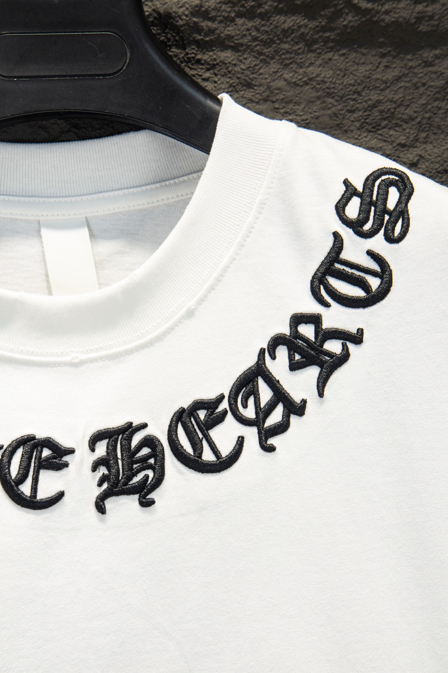White T-shirt with black embroidered logo on sleeve/shoulder