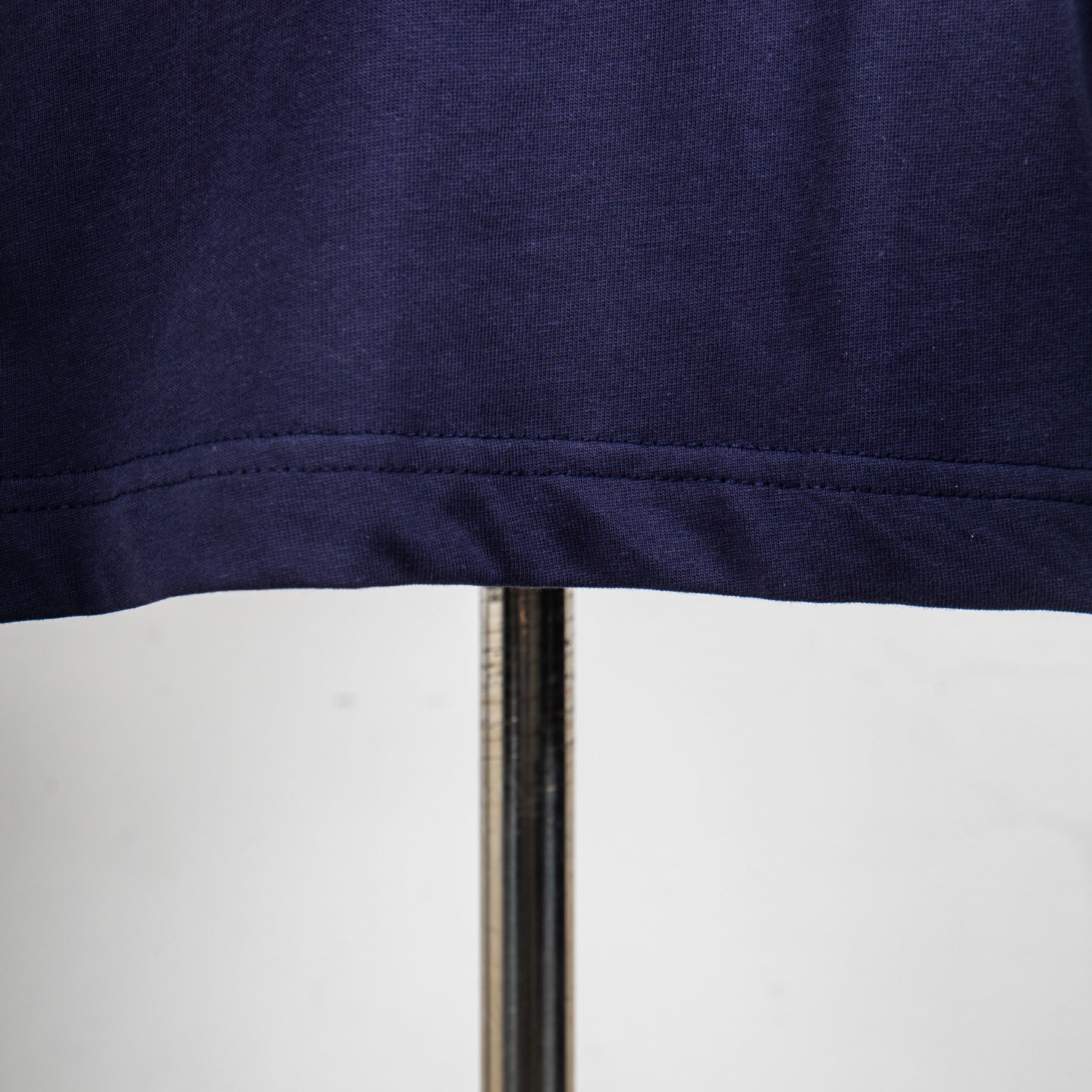 Navy short-sleeve top hem with visible stitching