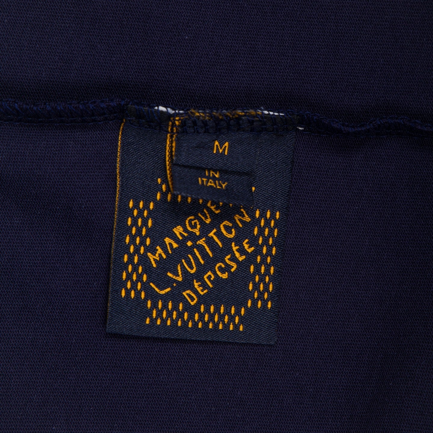 Inside neck label patch on navy top with “Made in Italy” text