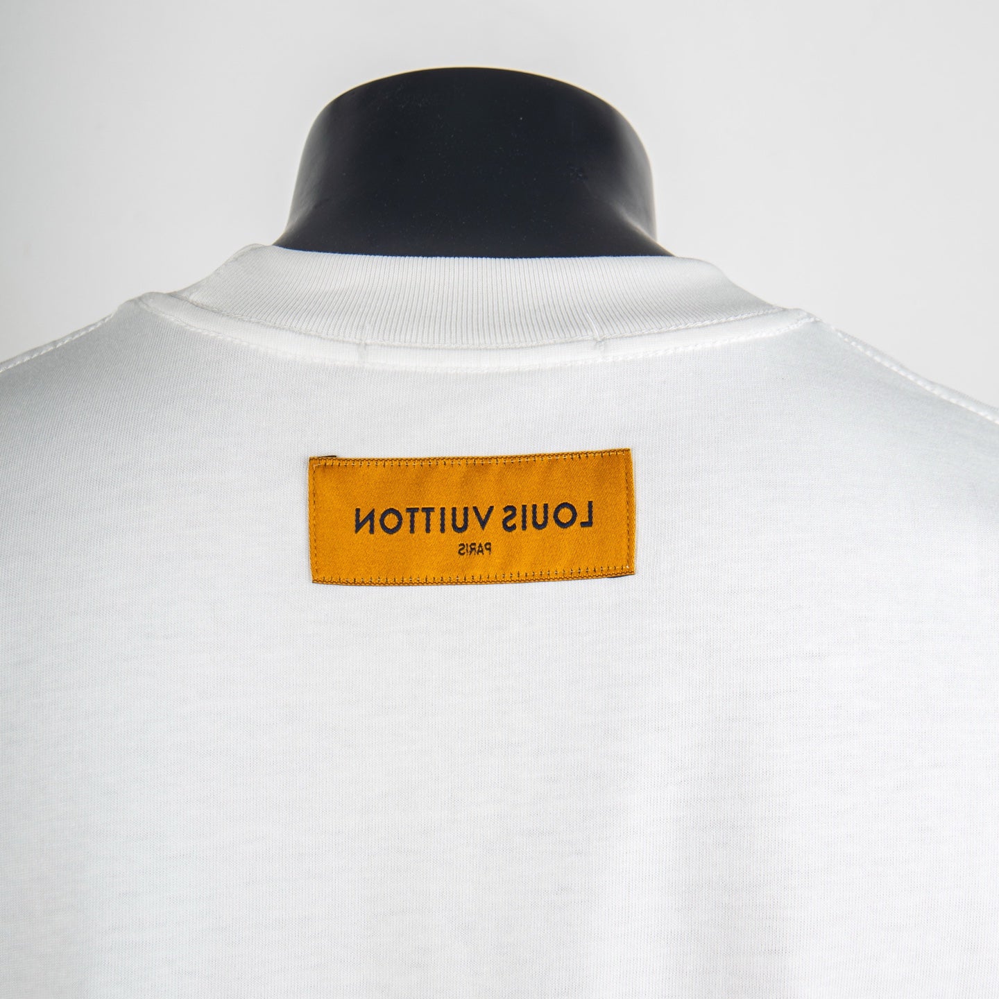 T-shirt back neck label in orange on white fabric