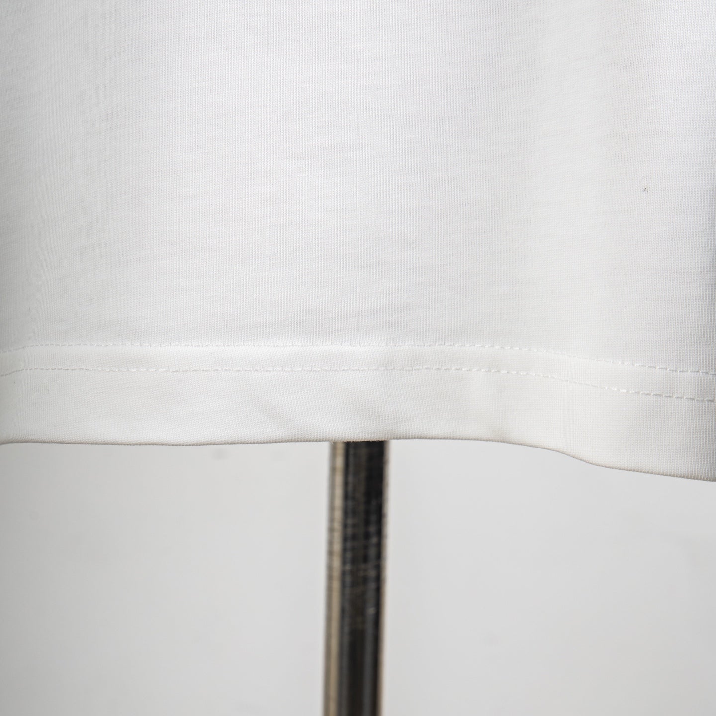 White T-shirt fabric texture and side seam stitching close-up