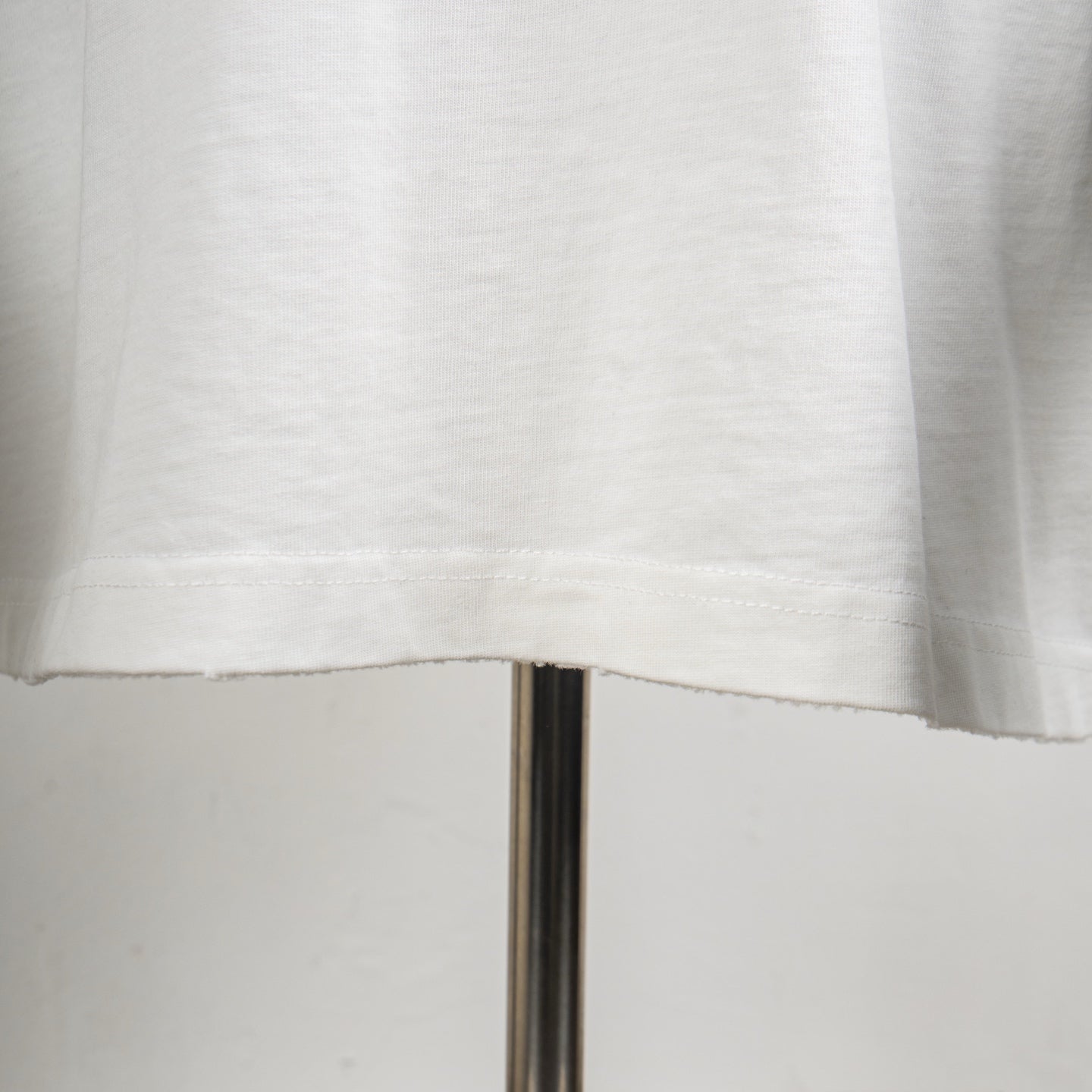 White T-shirt bottom hem and fabric texture close-up