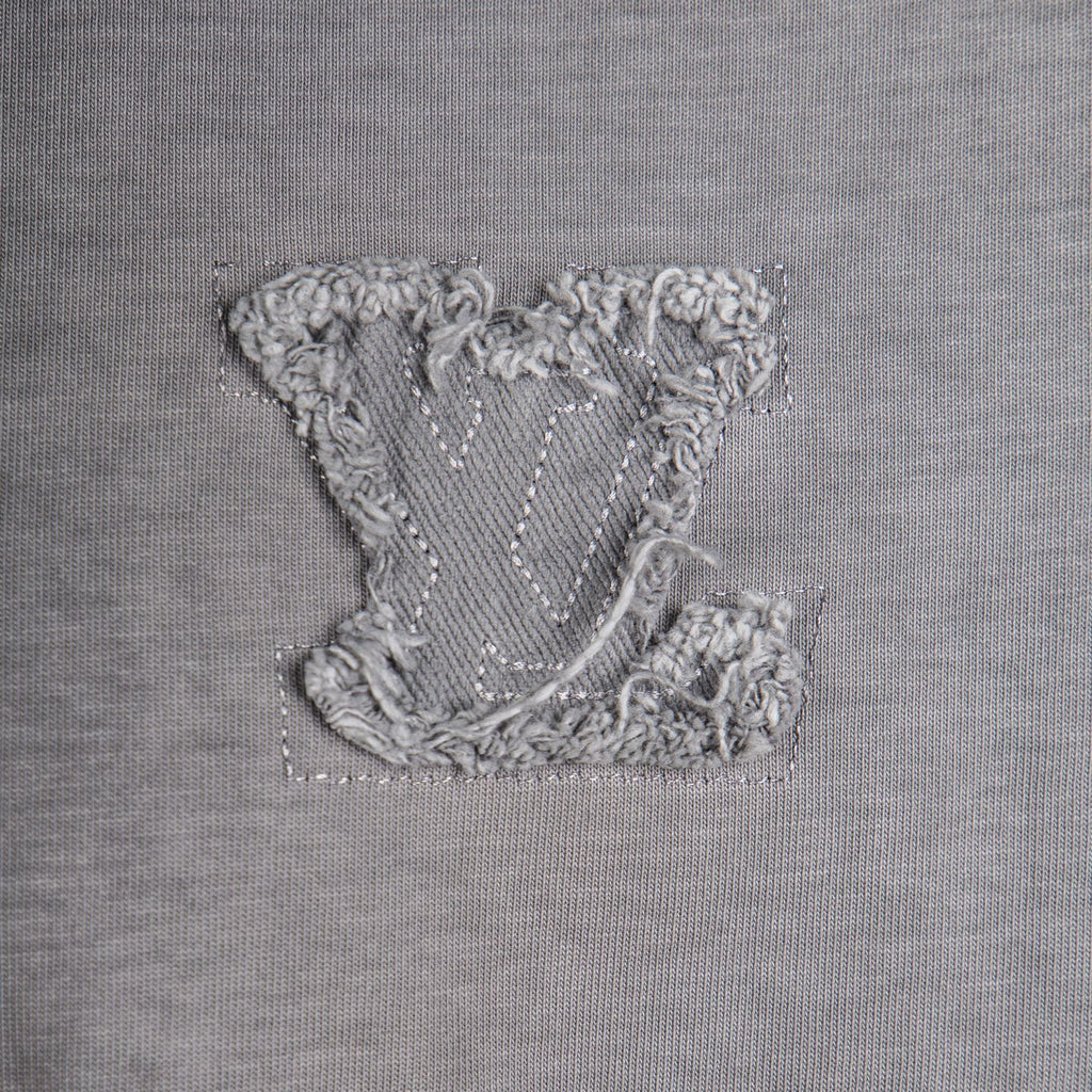 Embroidered crest patch on gray T-shirt front