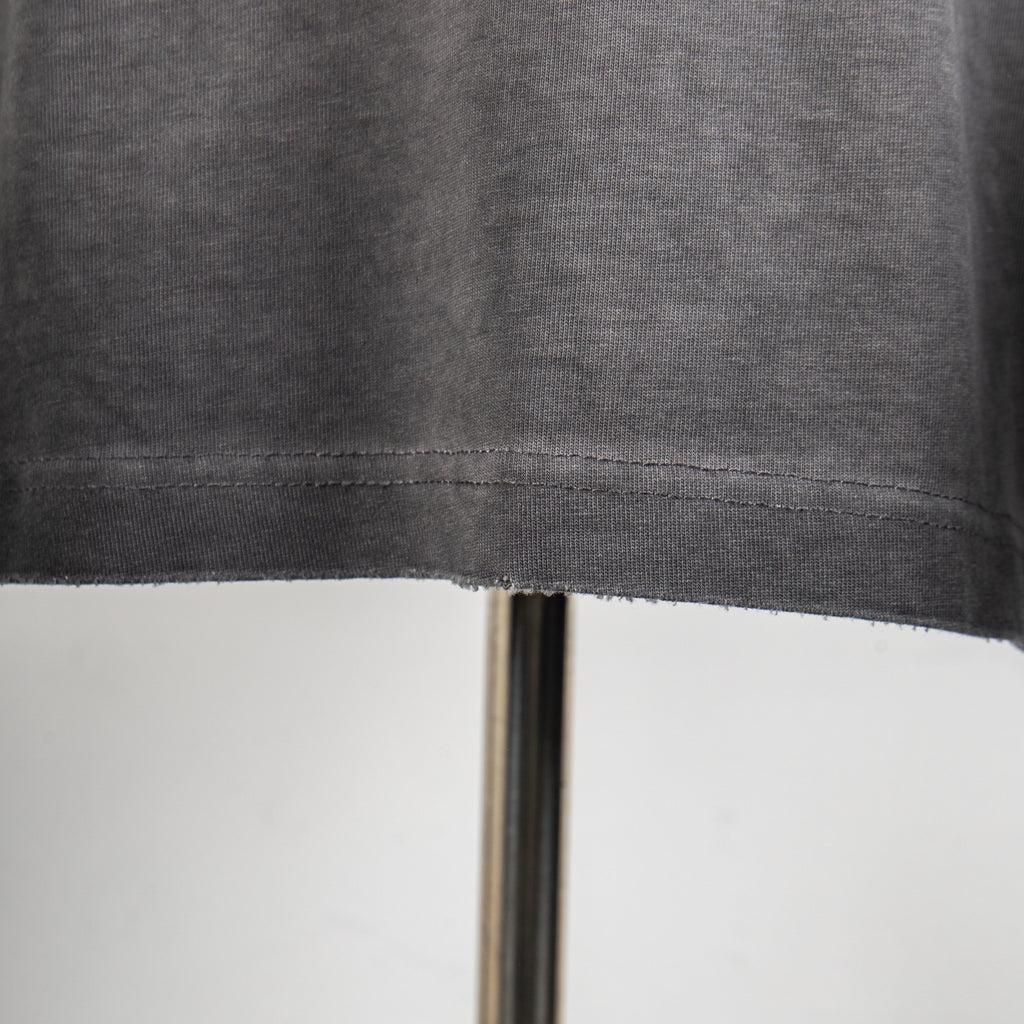 Grey T-shirt hem with visible stitch line