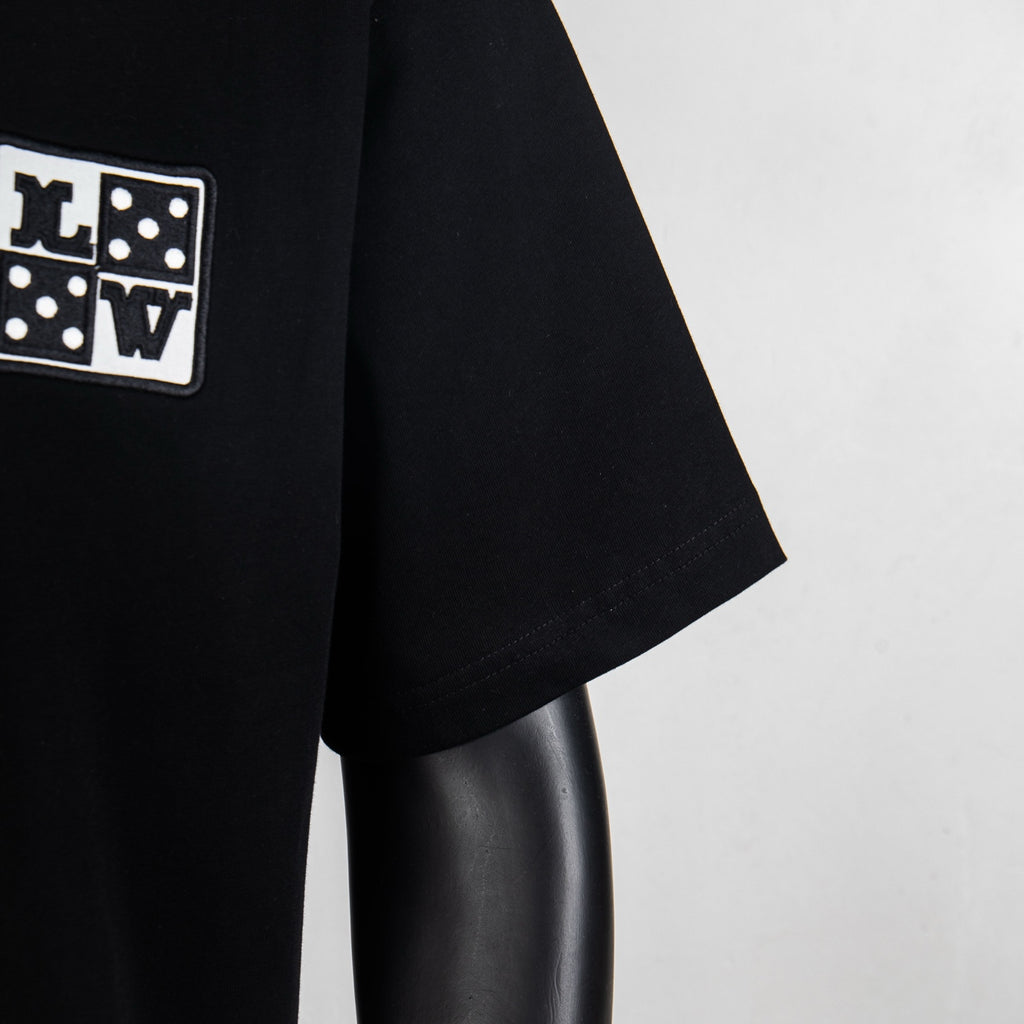 Black short-sleeve T-shirt sleeve detail with logo patch