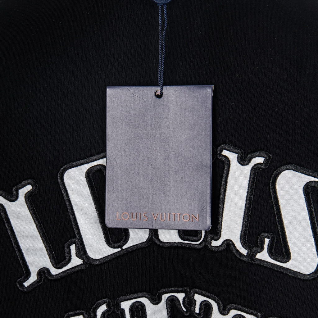 Black T-shirt with hanging tag and Louis Vuitton text graphic