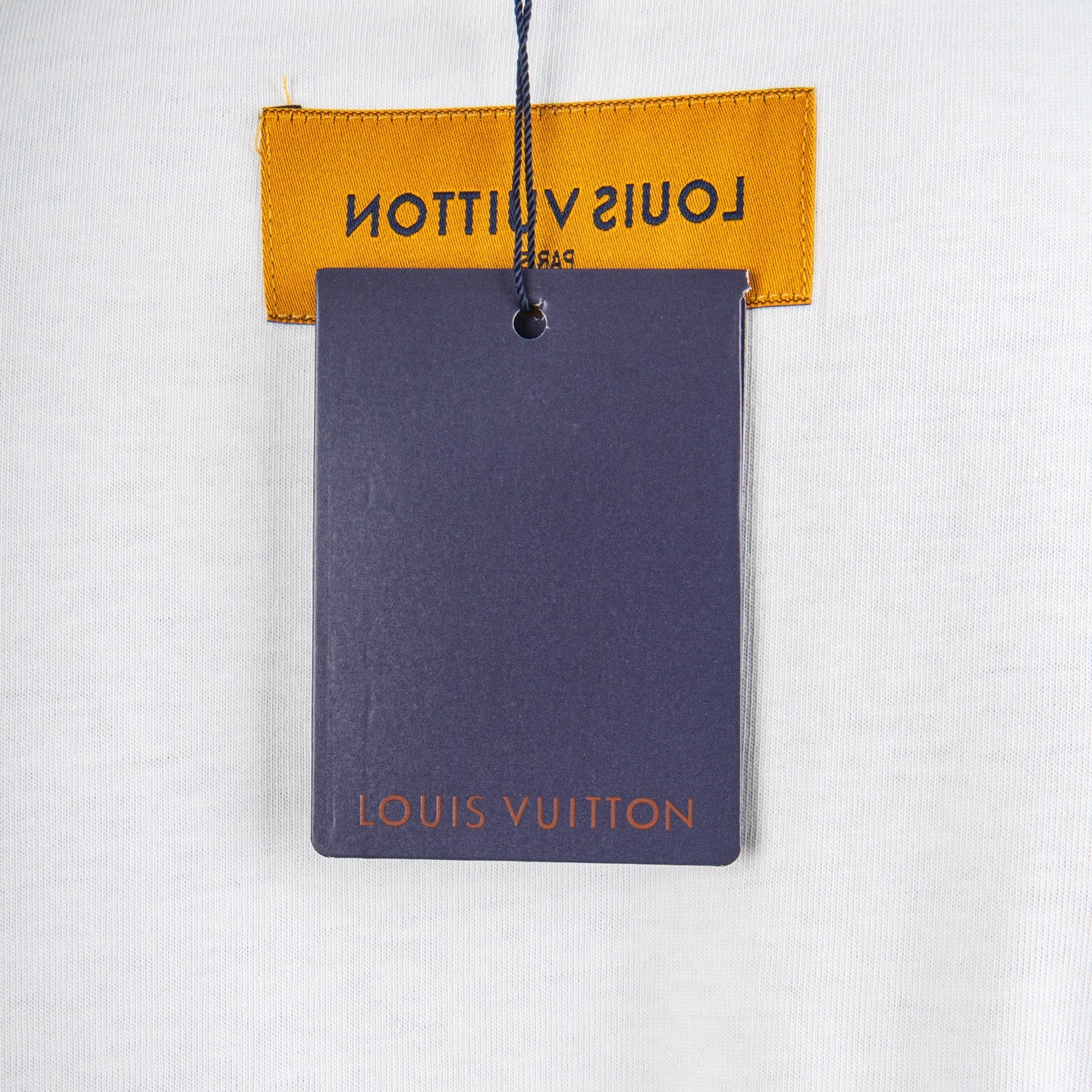 Louis Vuitton clothing tag on white T-shirt with orange label