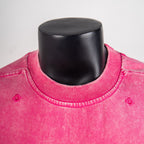 Pink crewneck T-shirt close-up with ribbed collar and small motif details