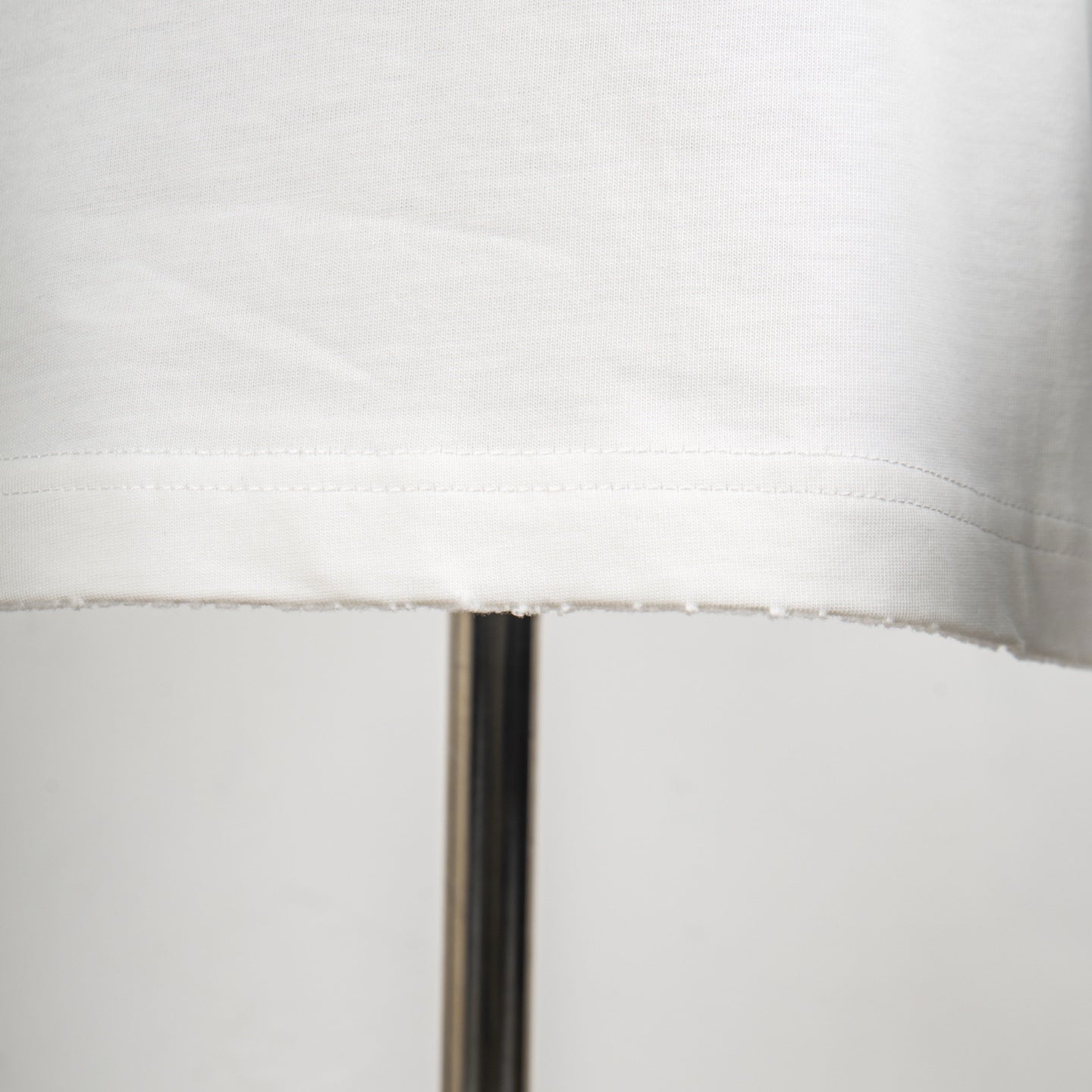 White T-shirt hem stitching and seam detail