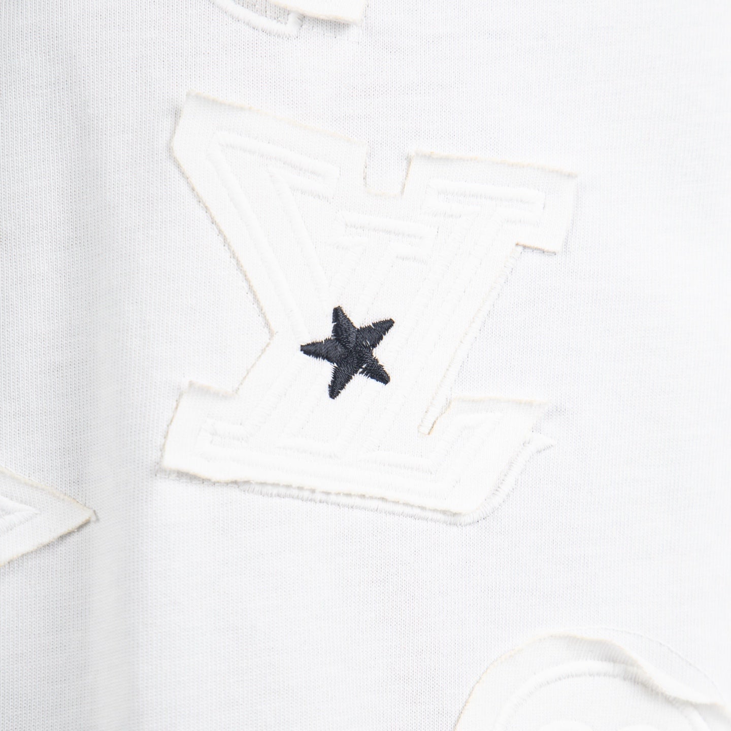 White T-shirt close-up of black star appliqué patch on the front