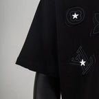 Black T-shirt side with raised circle star and LV-style print