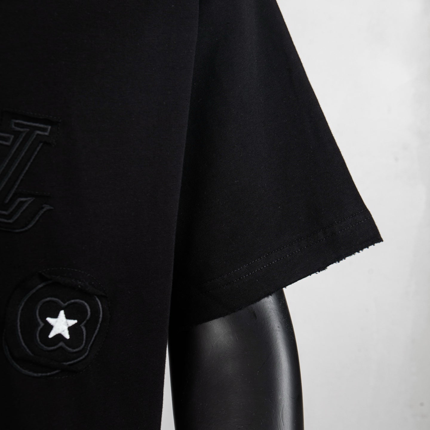 Black T-shirt sleeve and hem with circular star emblem