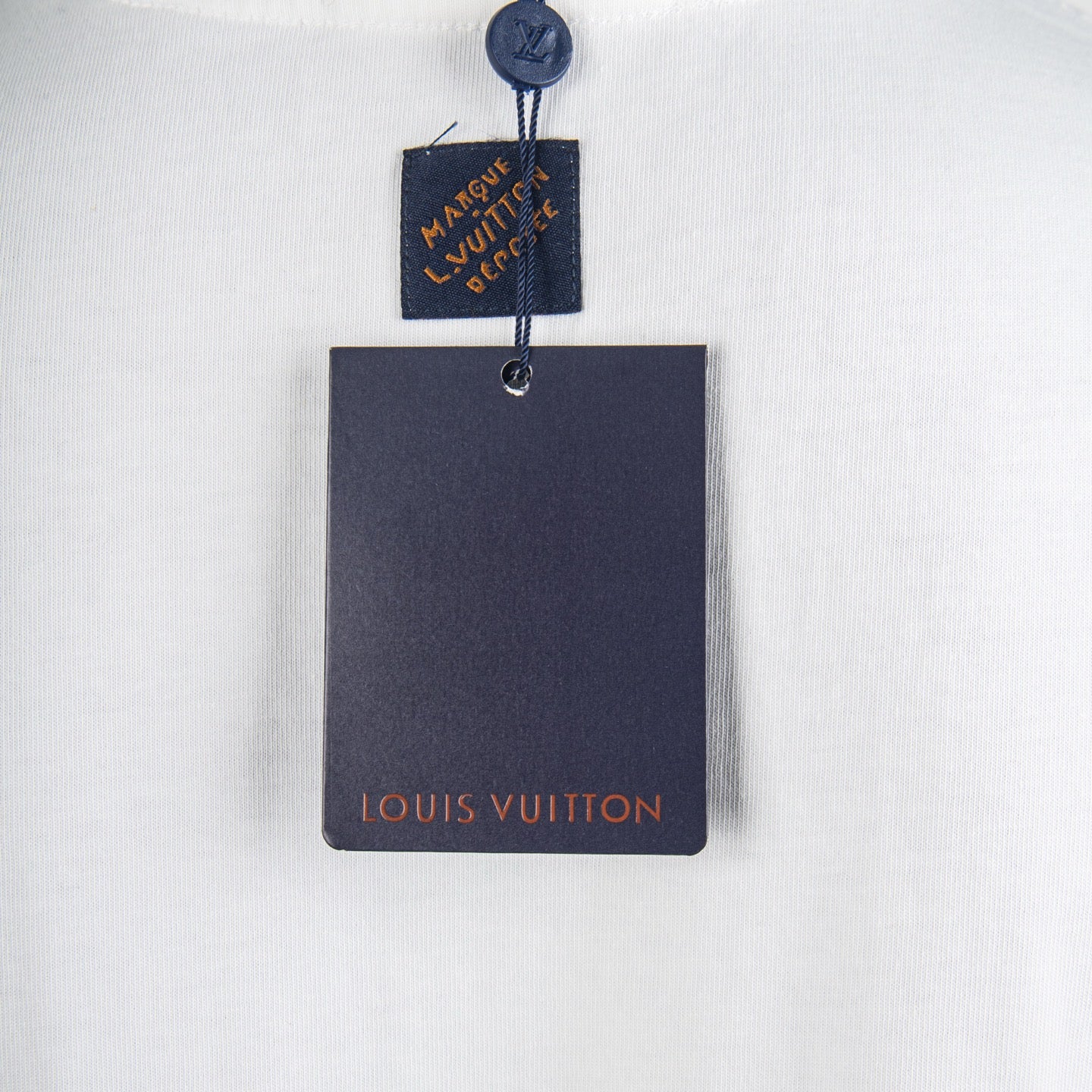 White T-shirt with attached blue neck label and Louis Vuitton hang tag