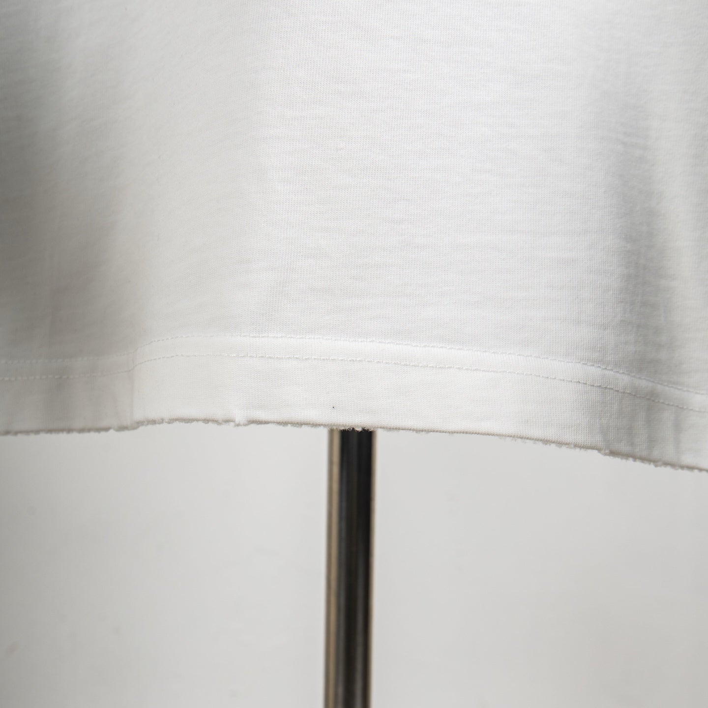 White T-shirt lower hem with visible stitching