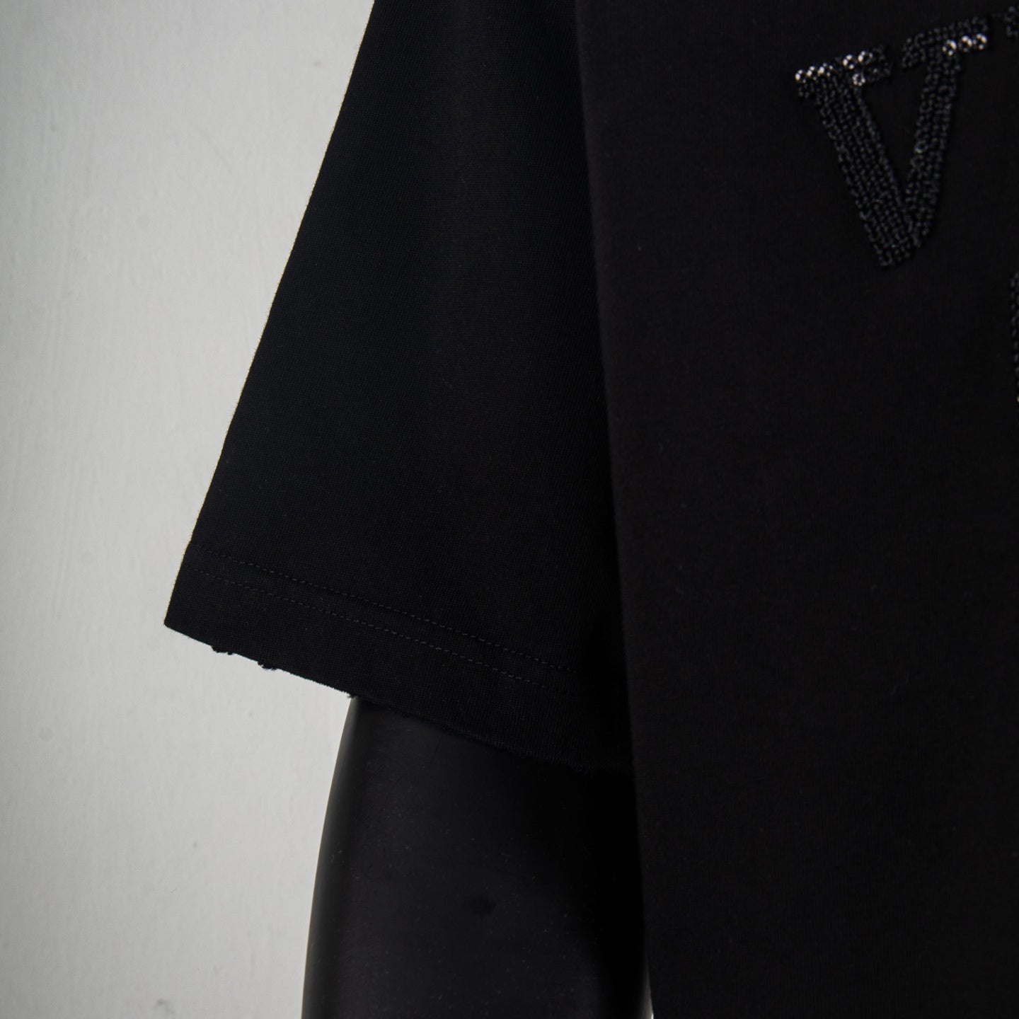 Black short-sleeve T-shirt side view with stitched hem