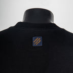 Black T-shirt back with small logo label near the collar