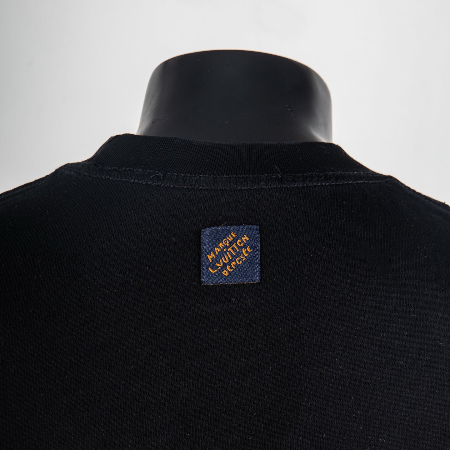 Black T-shirt back with small logo label near the collar