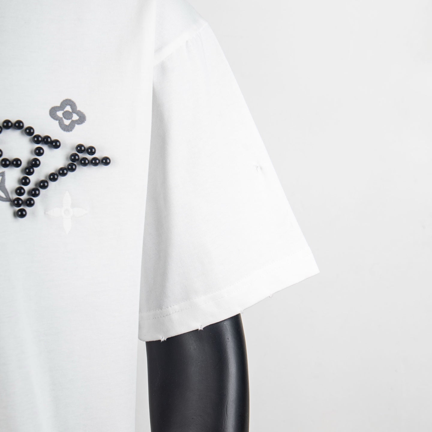 Louis Vuitton T-shirt side view, white fabric with visible seam and hem