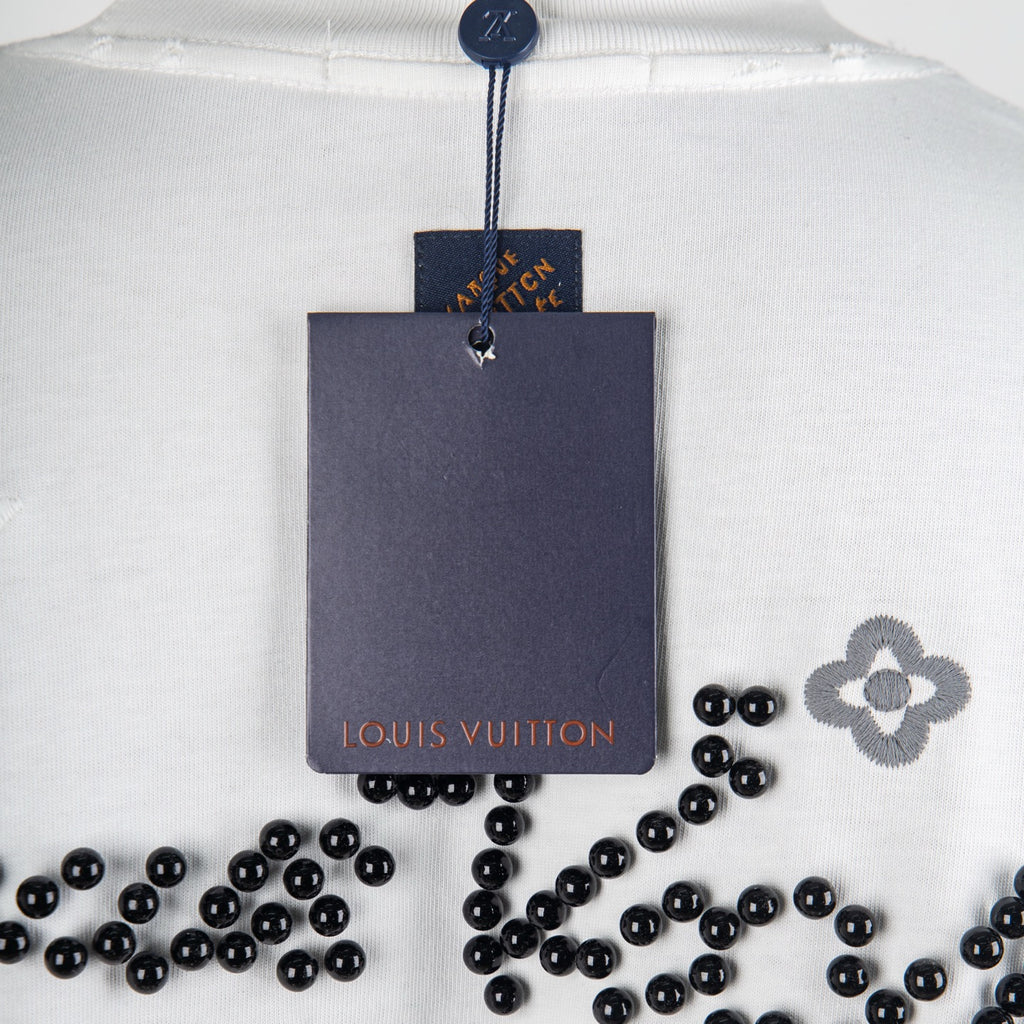 Louis Vuitton white T-shirt close-up with neck hang tag and black beaded motif