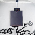 Louis Vuitton white T-shirt close-up with neck hang tag and black beaded motif