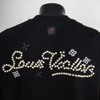 Black T-shirt with large pearl script and flower embellishment on the back