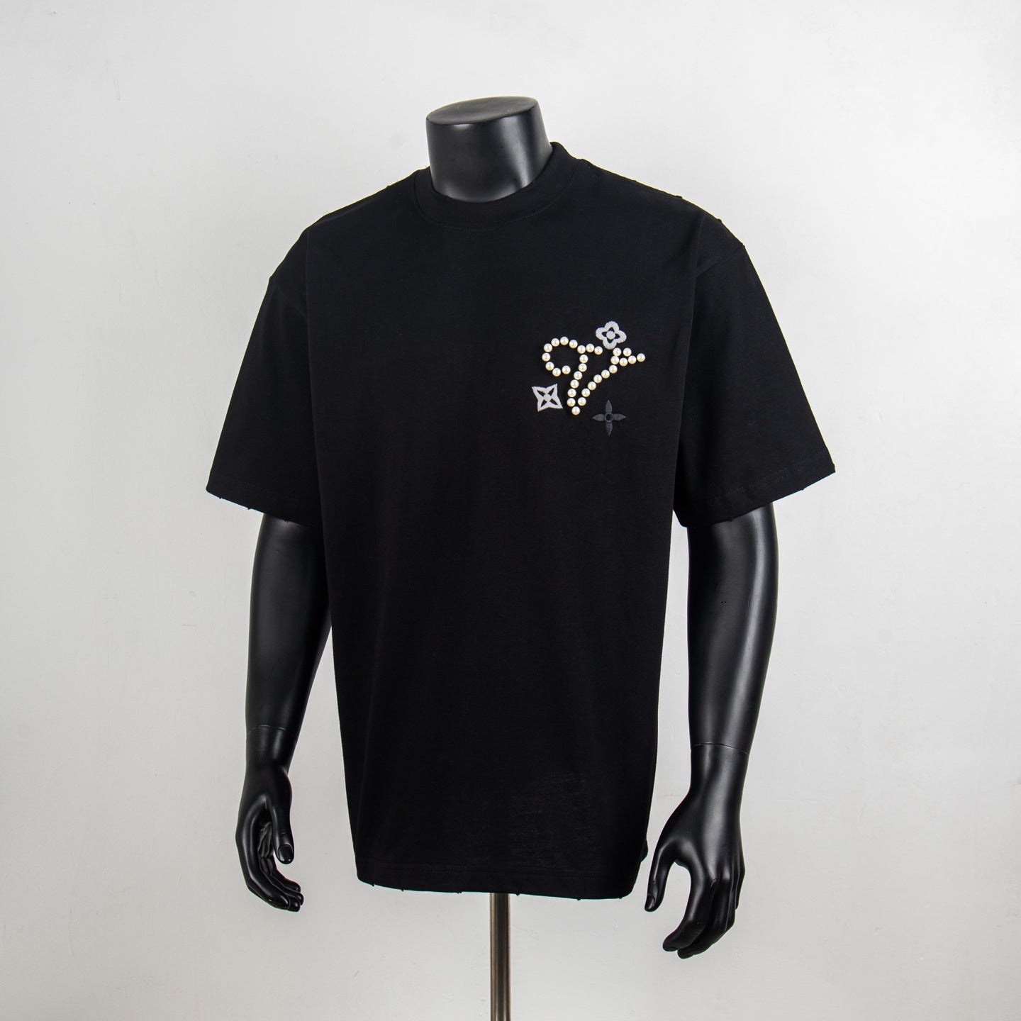 Black crewneck T-shirt with pearl and rhinestone star-flower motif on chest
