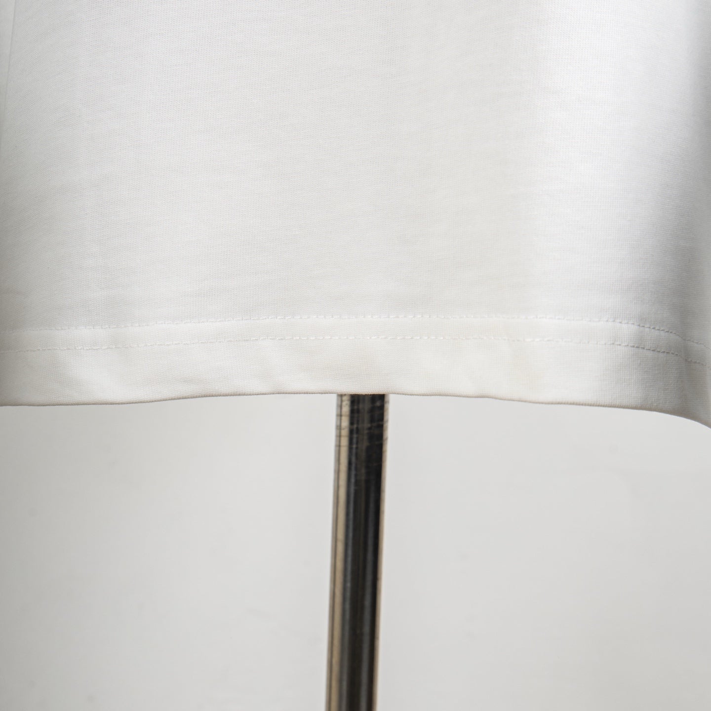 White T-shirt hem with visible double-stitched edge