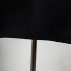 Black T-shirt hem with visible stitching and slight fabric texture
